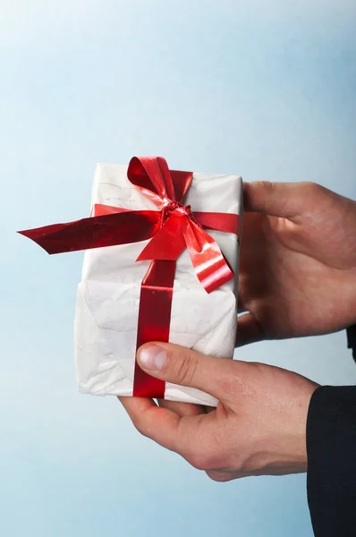 Homem feriado e oferecendo um presente em sua mão — Fotografia de Stock