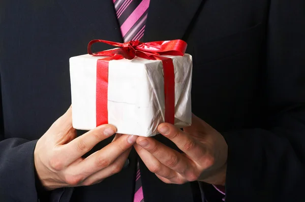Homem feriado e oferecendo um presente em sua mão — Fotografia de Stock