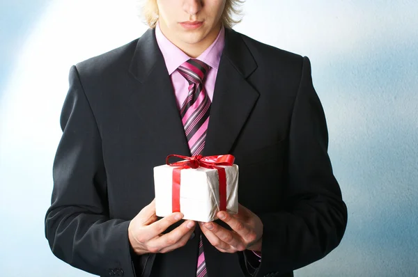 Adam tatil ve elinde bir hediye sunuyor — Stok fotoğraf