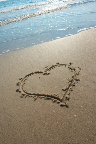 Серце намальоване на піску, море — стокове фото