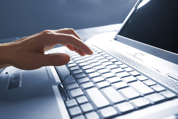 Мужские руки, печатающие на ноутбуке