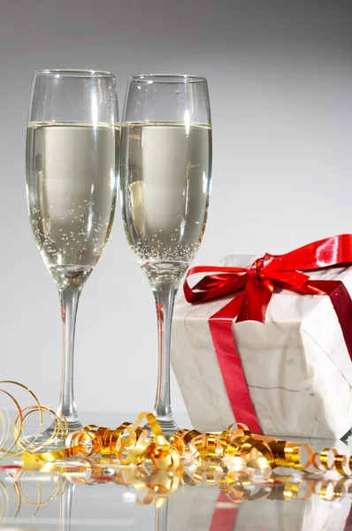 Pohár pezsgő, ajándékok, vörös szalagok és íjak — Stock Fotó