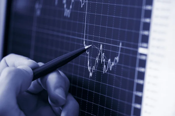 Рука бизнесмена показывает диаграмму финансового отчета ручкой — стоковое фото