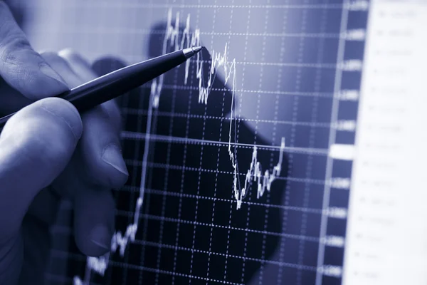 Рука бизнесмена показывает диаграмму финансового отчета ручкой — стоковое фото