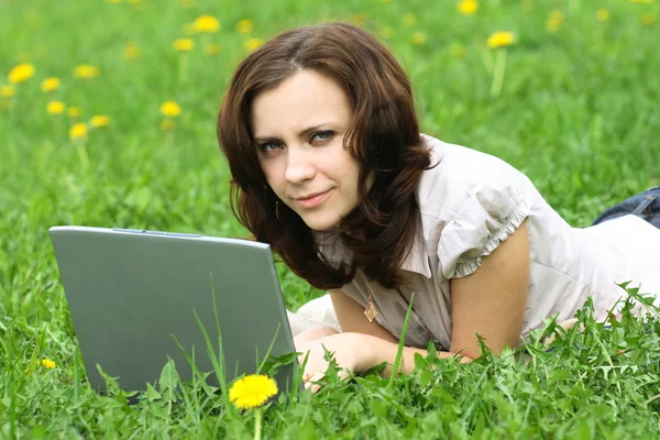 Het meisje met laptop over de aard Stockafbeelding