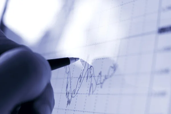 Mano del empresario mostrando diagrama en informe financiero con pluma —  Fotos de Stock