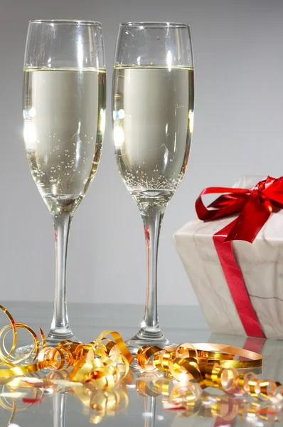 Lunettes de champagne, cadeaux avec rubans rouges et noeuds — Photo