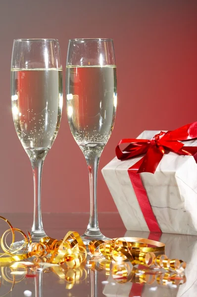 Kadeh şampanya, hediyeleri kırmızı bantları ve yay — Stok fotoğraf