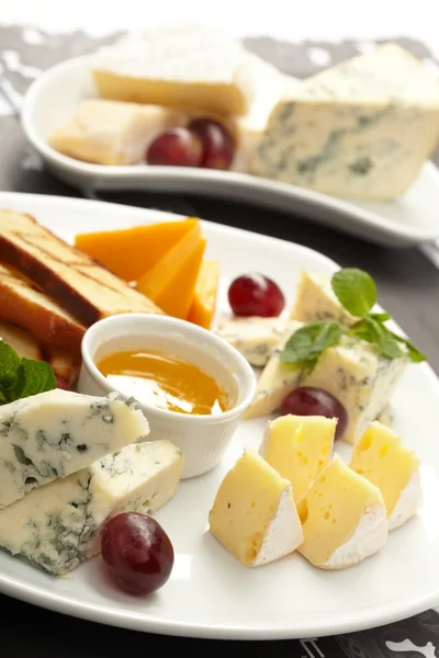Cheese plate with grapes and honey — Stock Photo, Image