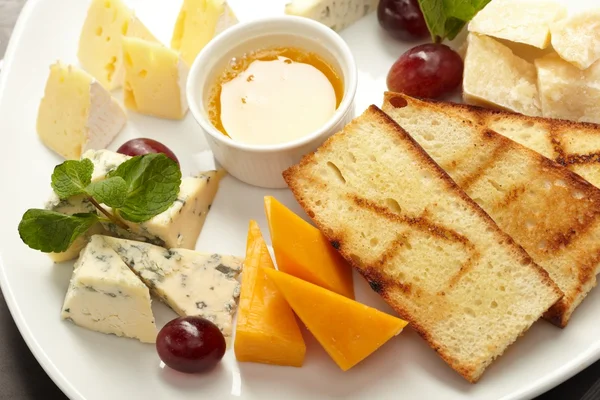 Cheese plate with grapes and honey — Stock Photo, Image