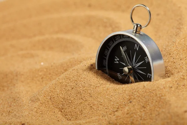 Компас в песке — стоковое фото