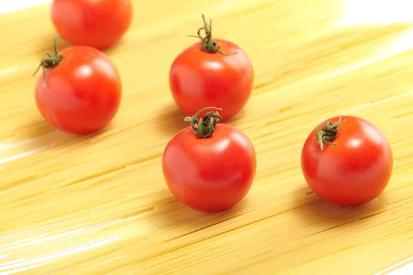 Esparguete cru e tomates frescos — Fotografia de Stock