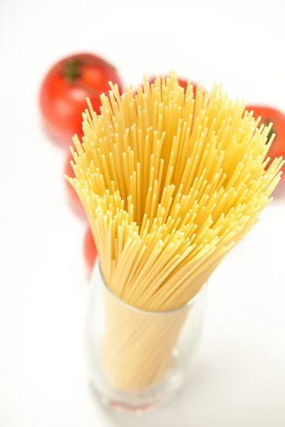 Raw spaghetti and fresh tomatoes — Stock Photo, Image