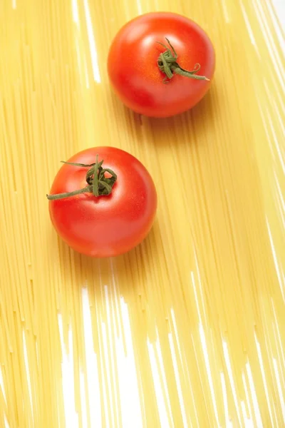 Esparguete cru e tomates frescos — Fotografia de Stock