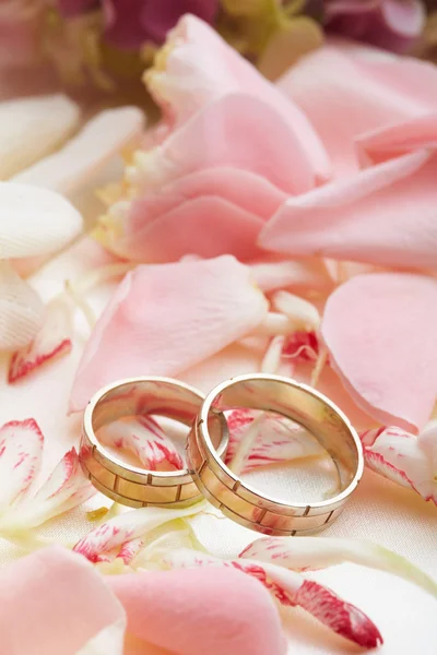 Goldene Ringe und Rosenblätter Stockbild