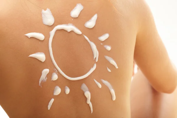 Femme avec crème solaire en forme de soleil — Photo