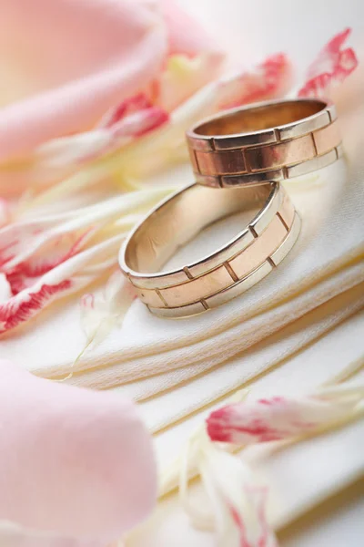 Gyllene ringar och rosenblad — Stockfoto
