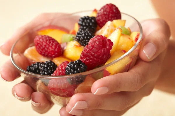 Fruit salad in the hands — Stock Photo, Image