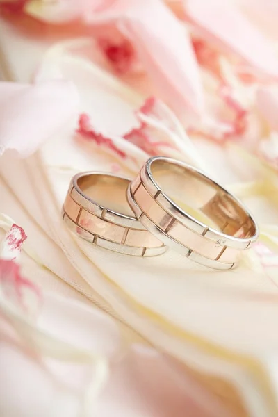 Золотые кольца и лепестки роз — стоковое фото