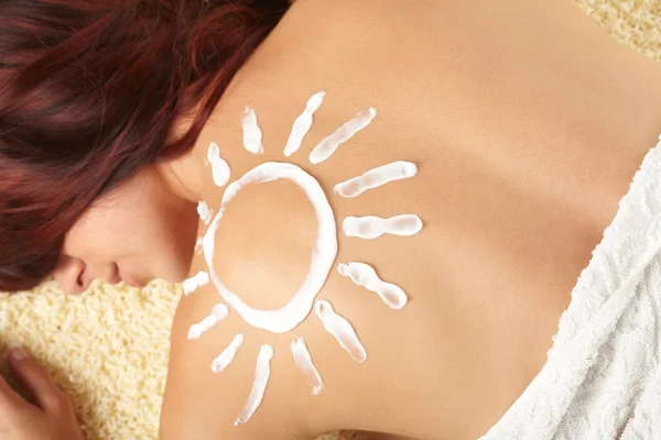 Frau mit sonnenförmiger Sonnencreme — Stockfoto