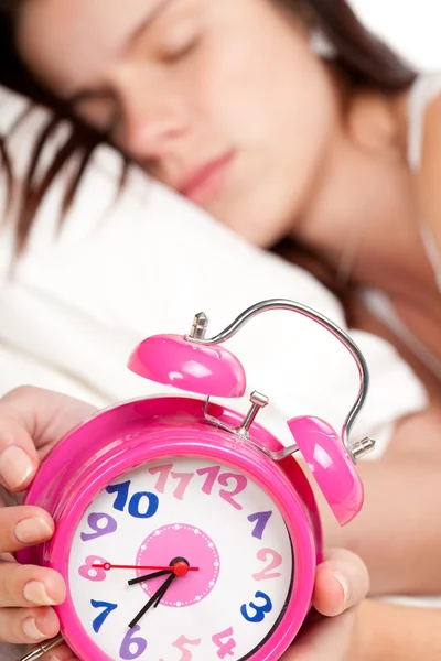 美しい女性の睡眠と目覚まし時計 ストックフォト