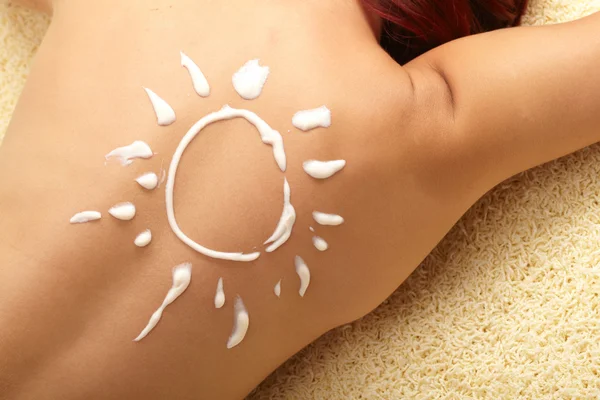 Kadın güneş şekilli güneş kremi ile — Stok fotoğraf