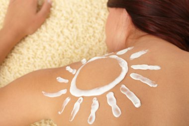 Woman with sun-shaped sun cream clipart