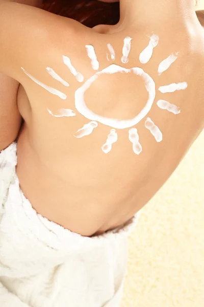 Vrouw met zon-vormige zonnebrandcrème — Stockfoto