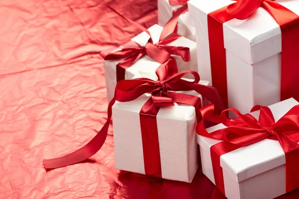 Prachtige geschenkdozen op de rode achtergrond — Stockfoto