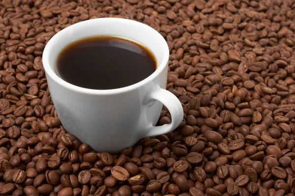 Tasse mit Kaffee, Kosten auf Kaffeekorn — Stockfoto