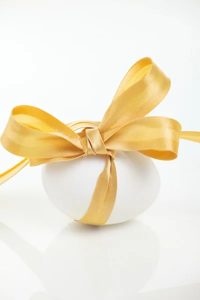 Easter egg with a bow golden — Stock Photo, Image