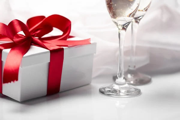 stock image Gift decorated with bow, glass wine