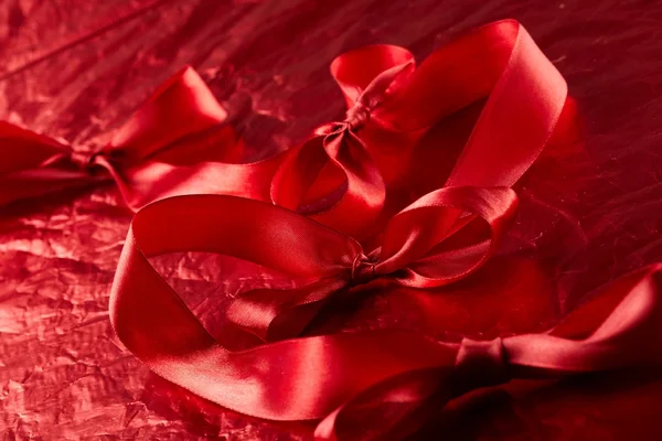 Satin ribbons on the red background — Stock Photo, Image