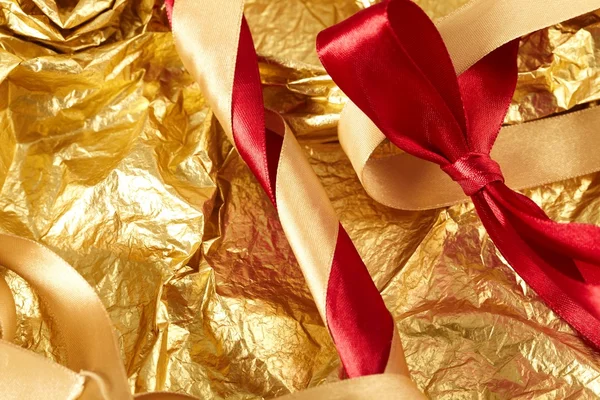 Satin ribbons on the gold background Stock Photo