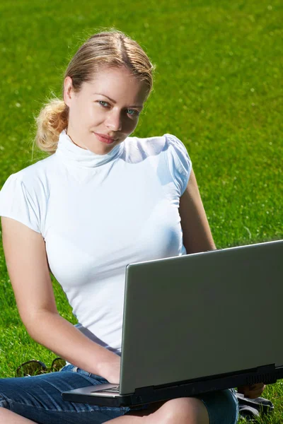 Dziewczyna z laptopa na zielony trawnik — Zdjęcie stockowe