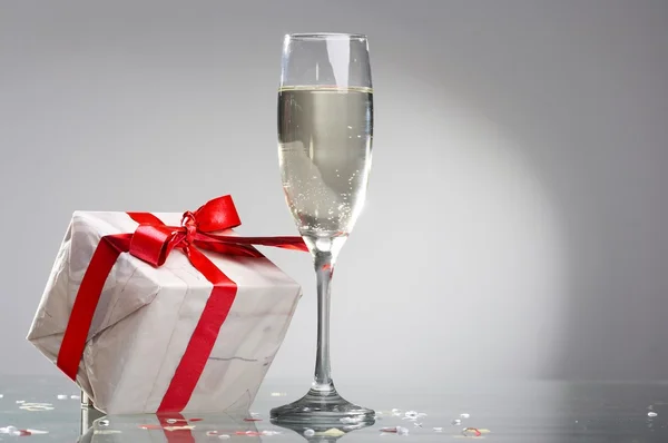 Bicchieri di champagne, regali con nastri rossi e fiocchi — Foto Stock