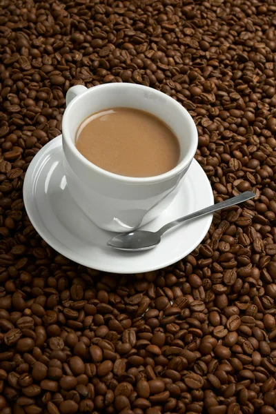 Hrnek s kávou, stojí na kávové zrno — Stock fotografie