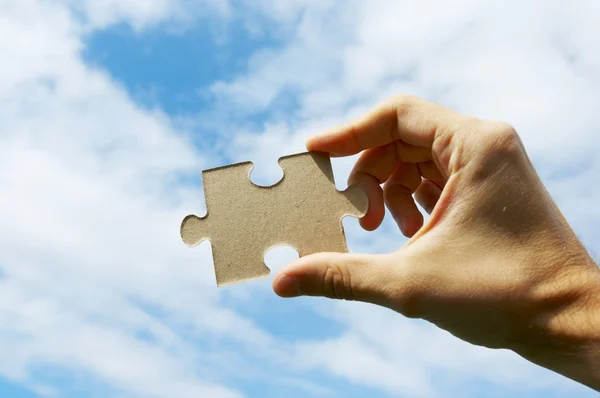 The hand holds puzzle on a background of the sky — Stock Photo, Image