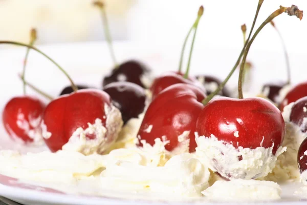 Cream, cherries on a white background — Stock Photo, Image