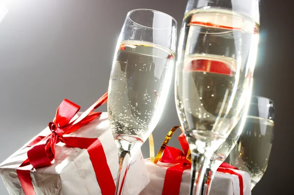 Copas de champán, regalos con cintas rojas y arcos —  Fotos de Stock