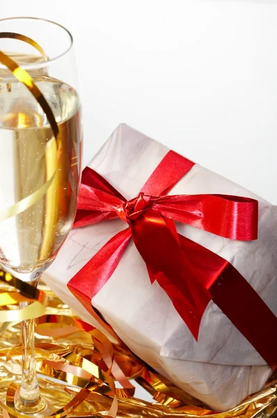 Glas champagne, gåvor med röda band och rosetter — Stockfoto