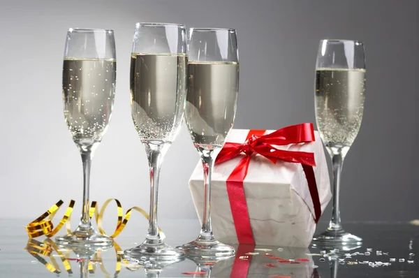Copas de champán, regalos con cintas rojas y arcos —  Fotos de Stock