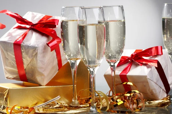 Champagneglass, gaver med røde bånd og sløyfer – stockfoto