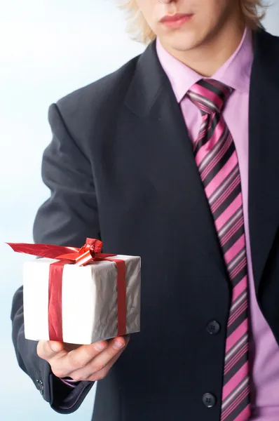 Adam tatil ve elinde bir hediye sunuyor — Stok fotoğraf