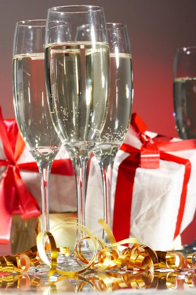 Kadeh şampanya, hediyeleri kırmızı bantları ve yay — Stok fotoğraf