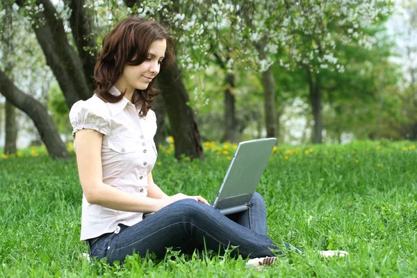 Девушка с ноутбуком на природе — стоковое фото