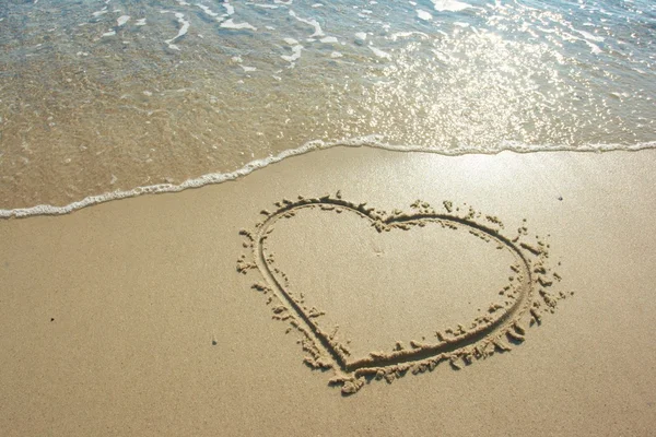Kalp üzerinde çizilmiş kum sahil — Stok fotoğraf