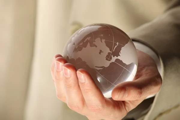 Empresário segurando mini globo — Fotografia de Stock