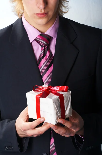 Muž dovolené a nabízí dárek na ruce — Stock fotografie