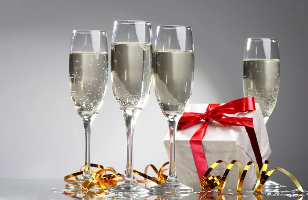 stock image Glasses of champagne, gifts with red tapes and bows